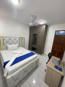 a bedroom with a bed and a desk with a laptop at Bellah Homes in Bamburi
