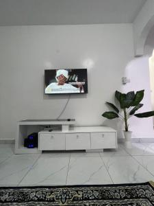 a white living room with a tv on a wall at Bellah Homes in Bamburi