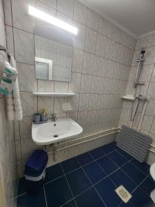 a bathroom with a white sink and a blue floor at La Livadă in Vama Veche