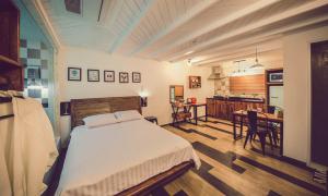 a bedroom with a bed and a kitchen with a table at La Beaute Jeju Pension in Seogwipo