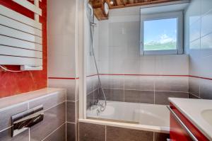 a bathroom with a tub and a sink at Appartement Tommeuse 93 in Tignes