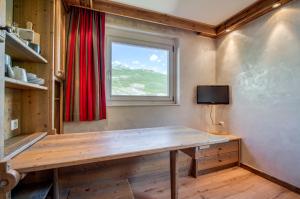 a room with a wooden table and a window at Appartement Tommeuse 93 in Tignes
