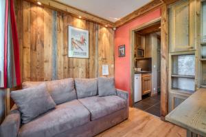 a living room with a couch and a kitchen at Appartement Tommeuse 93 in Tignes