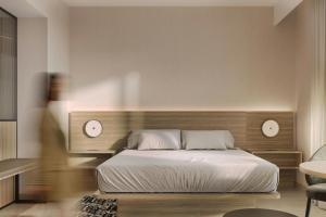 a bedroom with a bed with two clocks on the wall at AC Hotel by Marriott Denver RiNo in Denver