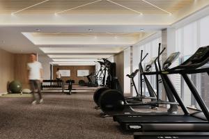 a man walking through a gym with cardio equipment at AC Hotel by Marriott Denver RiNo in Denver