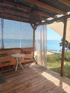 a patio with a table and chairs and the ocean at Ecoclub in Varna City