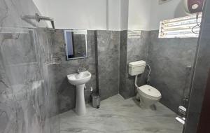 a bathroom with a sink and a toilet at Pearl Haven in Jorhat
