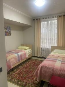 a bedroom with two beds and a window at Khan-toru in Pokrovka