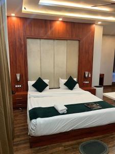 a bedroom with a large bed with a wooden headboard at Hotel V Square in Lucknow