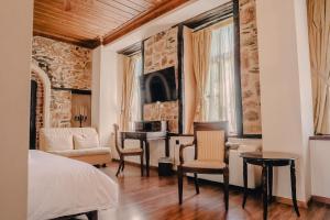 a bedroom with a bed and a desk with a piano at Palea Poli Boutique Hotel in Naousa