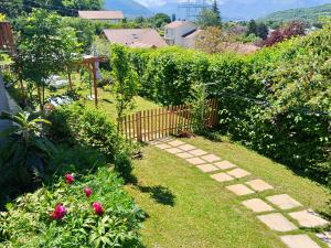a garden with a wooden fence and grass and flowers at L'Aparté Nature, entre campagne et montagne in Jarrie +33 photos