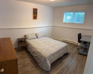 a bedroom with a bed and a desk and a window at Urban Midtown Stays in St. John's