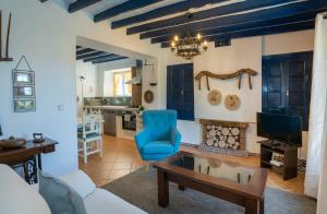 a living room with a blue chair and a table at Casa Altavista in Alora