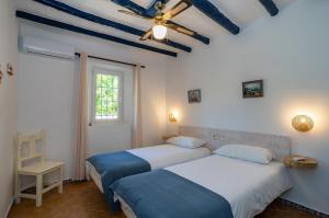 two beds in a room with a ceiling at Casa Altavista in Alora