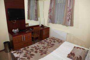 a bedroom with a bed and a desk and a television at Hotel Aquapark Žusterna in Koper +12 photos