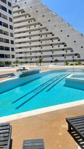 a large swimming pool in front of a large building at La PERLA DEL MORRO in Porlamar
