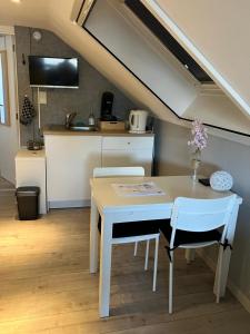 a kitchen with a table and chairs in a room at Le Flanelmont in Theux
