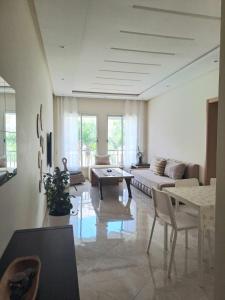 a living room with a couch and a table at Chaleureux appartement in Bouznika