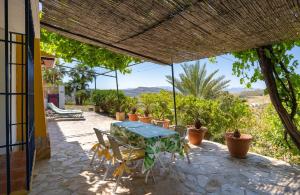 a table and chairs on a patio with plants at Casa Altavista in Alora