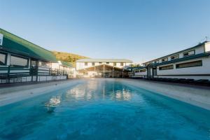 a pool of blue water in front of buildings at Chico Hot Springs Resort in White City