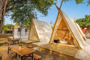 a couple of tents with a table and a picnic table at Kampaoh El Palmar in El Palmar