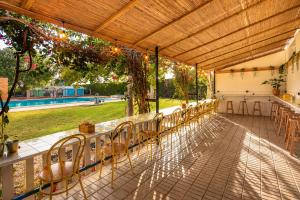a row of tables and chairs under a pavilion at Kampaoh El Palmar in El Palmar