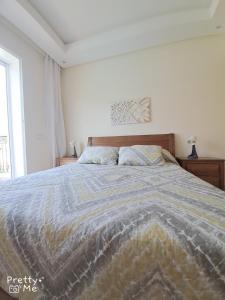 a bedroom with a large bed with a blanket at Chaleureux appartement in Bouznika