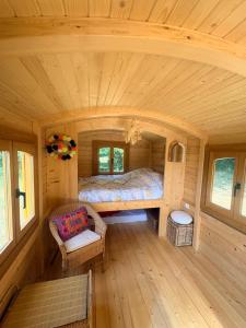 a bedroom in a tiny house with a bed at La roulotte de Clemence in Montfermy