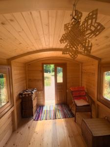a room in a log cabin with a chandelier at La roulotte de Clemence in Montfermy +11 photos