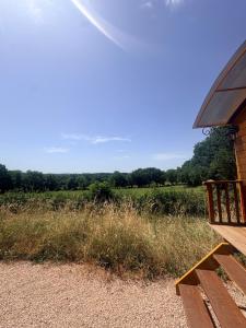 a porch of a house with a view of a field at La roulotte de Clemence in Montfermy