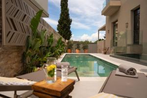 a house with a swimming pool with a vase of flowers on a table at Aetheria Boutique Hotel & Spa in Markopoulo