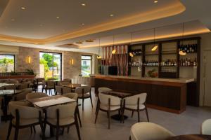 a restaurant with tables and chairs and a bar at Aetheria Boutique Hotel & Spa in Markopoulo