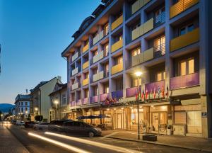 a hotel with cars parked outside of it on a street at Hotel Urpín City in Banská Bystrica