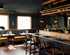 a dining room with tables and chairs and a bar at The Grand Hotel in Kennebunk