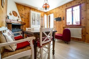a dining room with a table and chairs and wooden walls at Un piccolo nido accogliente in Fanano