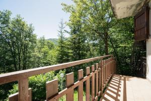 a wooden deck with a view of the woods at Un piccolo nido accogliente in Fanano