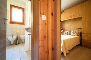 a bedroom with a bed and a sink and a bathroom at Un piccolo nido accogliente in Fanano