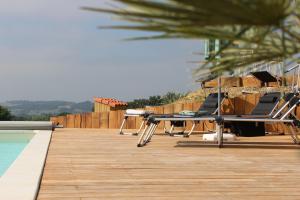 a deck with chairs and a table and a pool at Lôu cayrou in Beaumarches