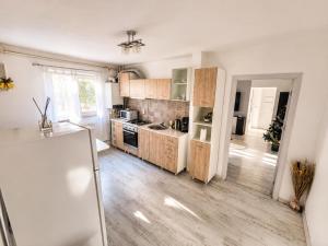 a kitchen with white walls and wooden cabinets at Apartament Rovine in Craiova