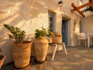 a group of potted plants sitting on a patio at Chora Heritage Residence by Belle-Stay in Patmos