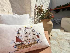a pillow with a ship on it sitting on a couch at Chora Heritage Residence by Belle-Stay in Patmos
