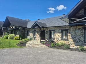 a stone house with a driveway in front of it at Loft La Pause Orford in Magog-Orford