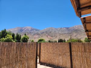 a wooden fence with mountains in the background at La Gauda in Huacalera