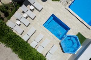 an overhead view of a swimming pool with white chairs at Bile - Family Hotel & Gastro Bar in Beli Osŭm +48 photos