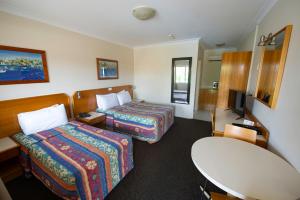 a hotel room with two beds and a table at Narellan Motor Inn in Narellan +59 photos
