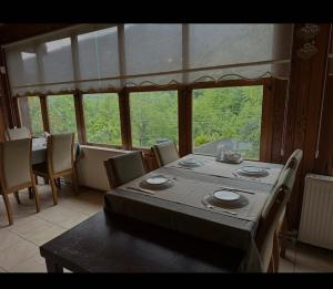 a dining room with a table and chairs and a large window at Özde Dağ Evi in Sapanca