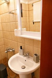 a bathroom with a white sink and a mirror at Olive Garden Vila in Karianí +33 photos