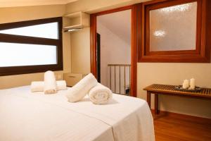 a bedroom with a bed with towels on it at Olive Garden Vila in Karianí