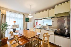 a kitchen with a table and chairs in a room at Kokonimo Kawagoesenba in Kawagoe