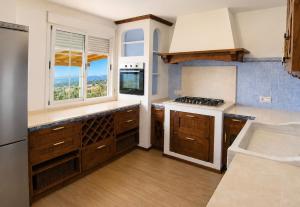 a kitchen with wooden cabinets and a stove top oven at Bello horizonte in Coín